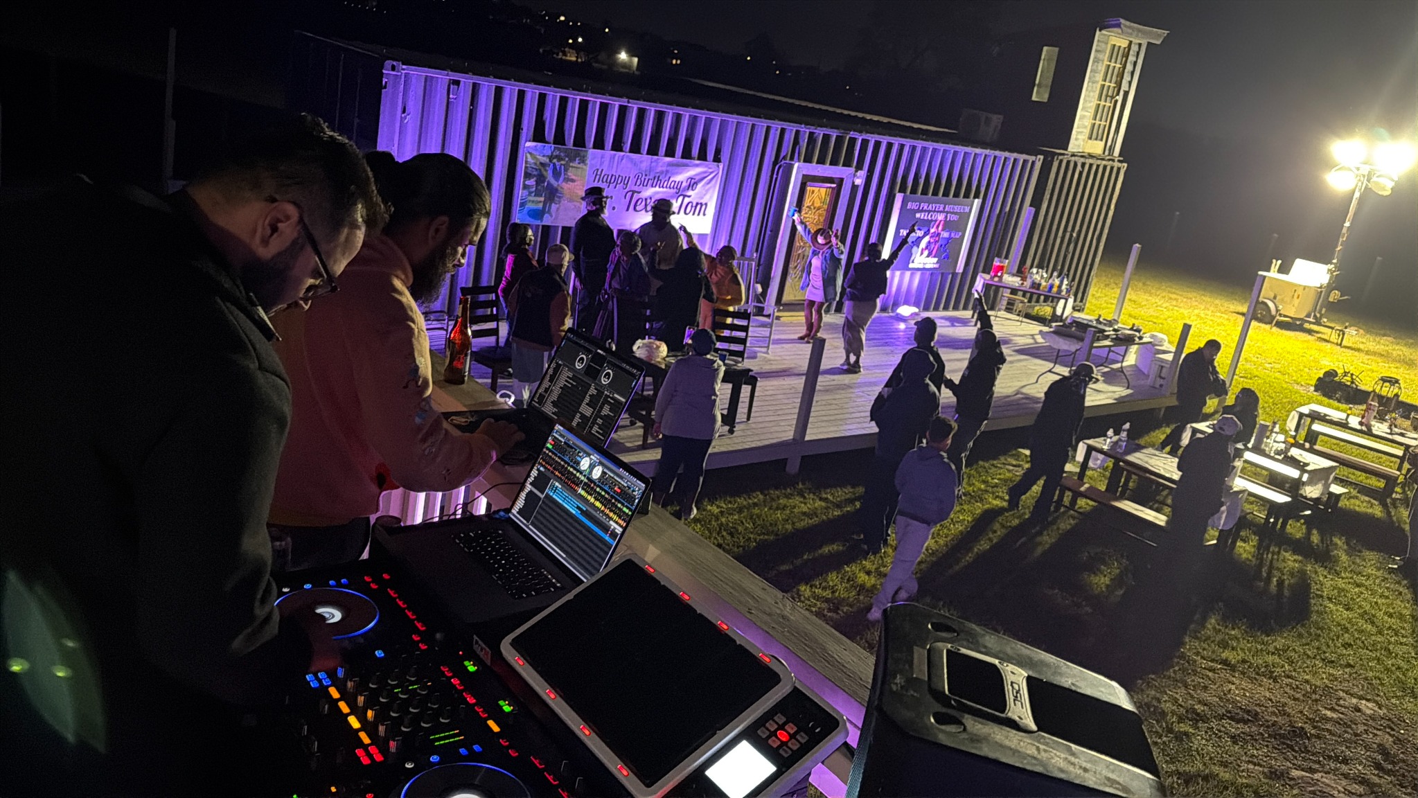 Nighttime gathering and DJ setup at the Big Prayer Museum Campus